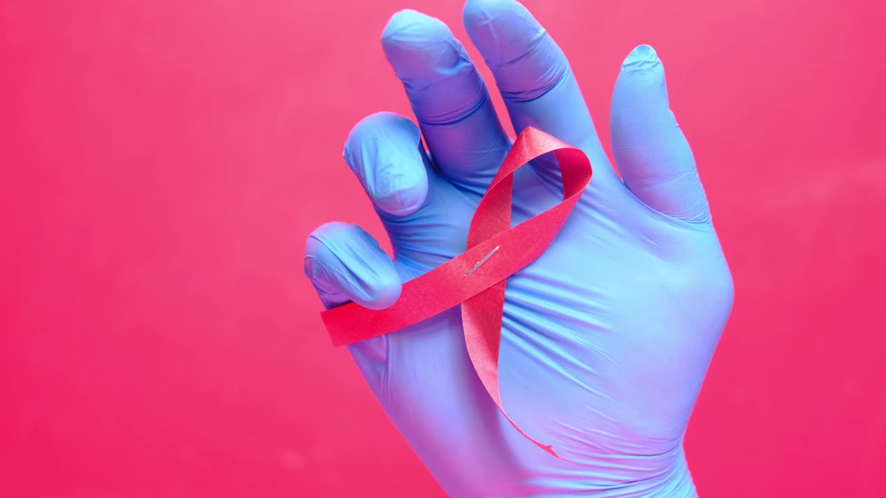 cinta rosada en una mano con guante