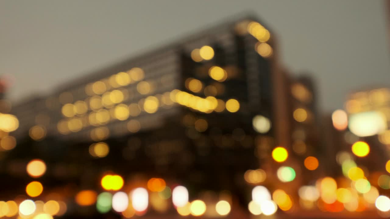 4k tono cálido desfocalizar video de vista nocturna urbana con transporte y transeúntes
