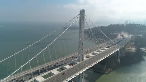 aerial shot of vehicles moving on san francisco–oakland bay bridge with city in background