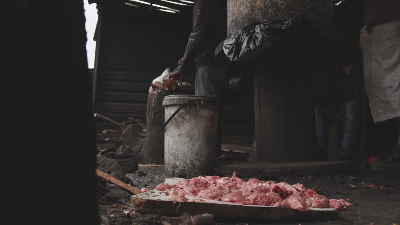 아프리카 사람 이 고기 를 자르고 있다