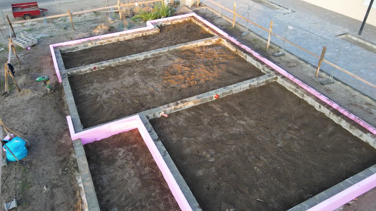 House foundation in drone view during construction with pipes and insulation