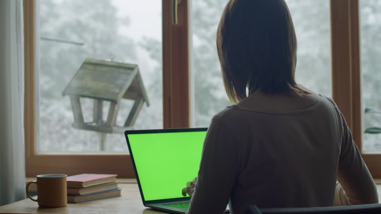 집에서 창문으로 일하면서 치키디를 먹이는 모바일 사진을 찍는 인식 할 수없는 여자. 실내에서 비행하는 새를 사진 찍는 소녀의 뒷면. 슬로우 모션. 스마트폰 응용 프로그램 기술