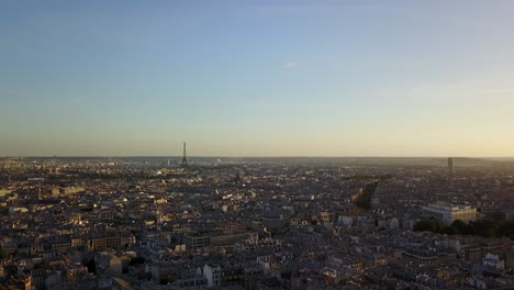 Aerial-ascending-footage-of-cityscape-in-sunset-time.-City-centre-and-dominant-Eiffel-Tower.-Paris,-France