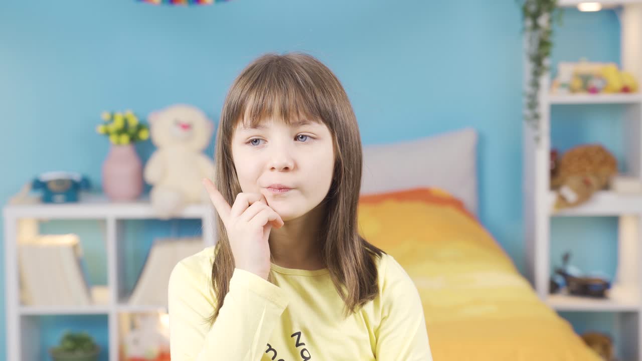 una niña linda y pensativa pensando en una idea, tocándose la barbilla.