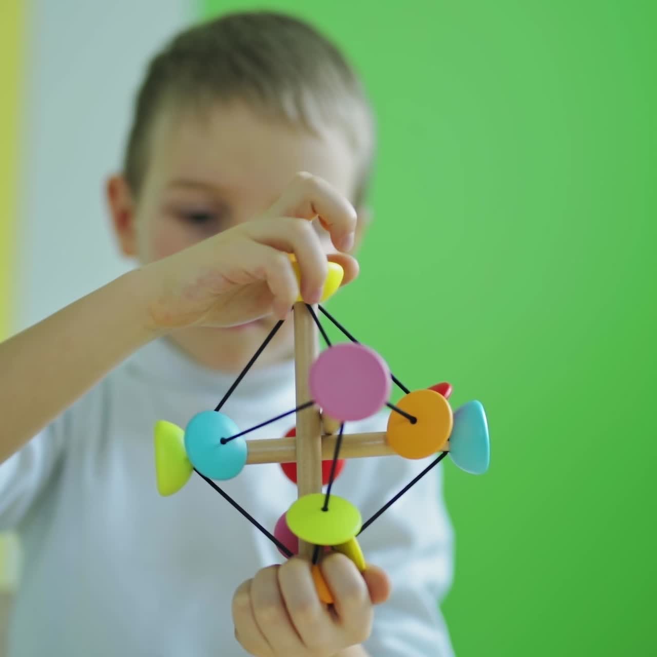 Child playing educational toy at home. Cute little kid playing developing games. Colorful toy in boy's hands in the room.