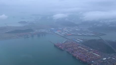 aerial view of a busy port with container ships and industrial area