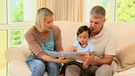 padres leyendo un libro para su pequeño bebé