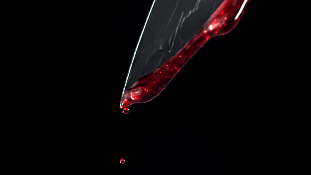 Nærbillede af rød væske, der drypper fra et knivsblad i slowmotion