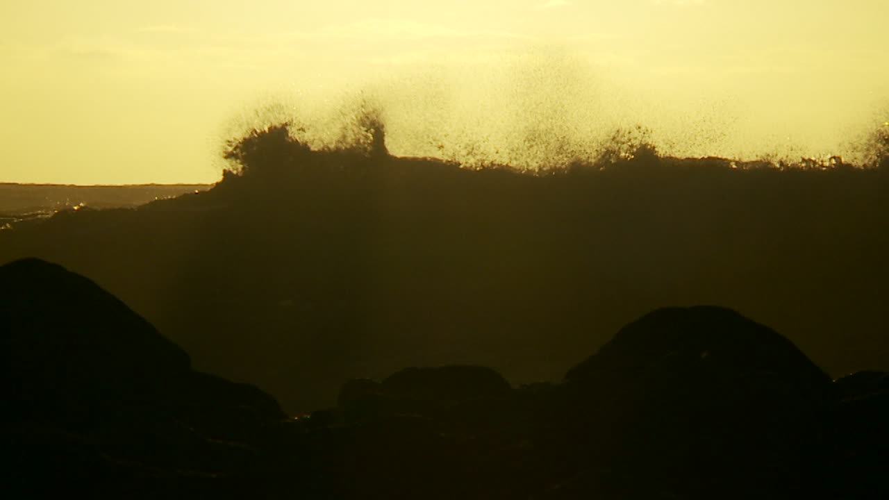 일몰 2에서 슬로우 모션으로 볏과 부서지는 큰 파도