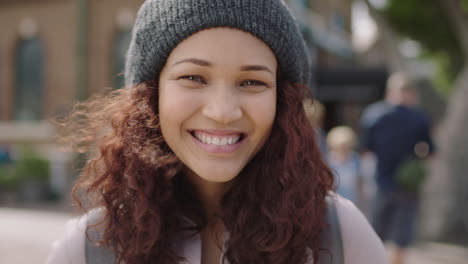 close up portrait of pretty mixed race girl smiling happy at camera wearing beanie hat