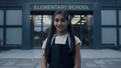 indian school girl standing at campus entrance closeup. teenager looking camera.