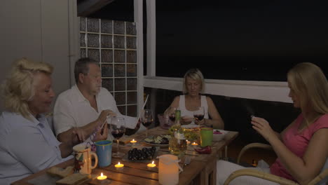 family using cells and laptop during dinner