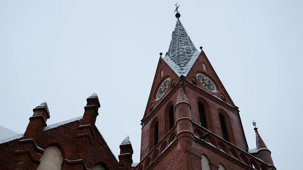 Esterno di una storica chiesa gotica in un rigido paesaggio invernale.
