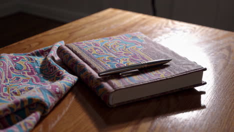 decorative notebook and pen on a wooden table