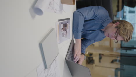 mid-aged architect typing on laptop at work in the office