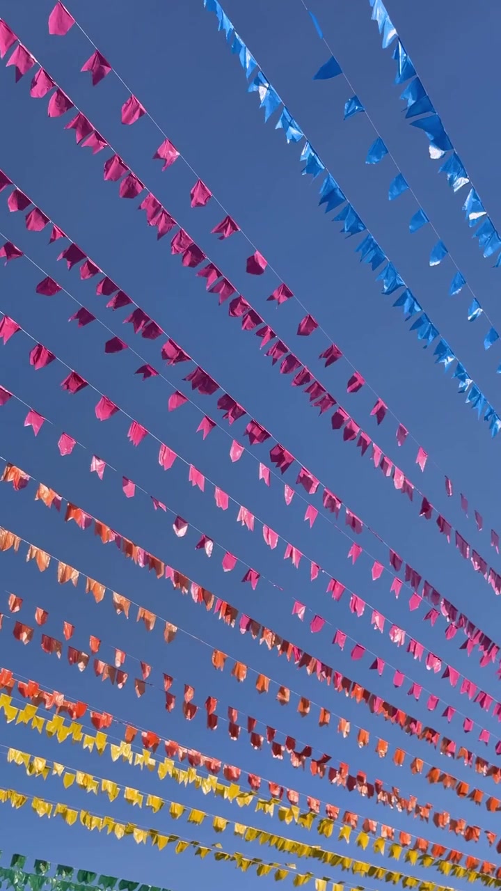 Bandierine colorate e festive contro un cielo azzurro brillante