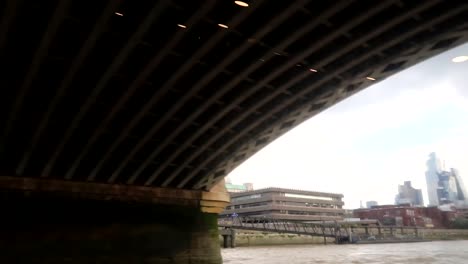 hand-held-shot-of-a-boat-trip-heading-under-Blackfriars-Bridge-on-the-Thames-River,-London