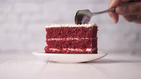 a slice of red velvet cake being eaten