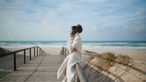 worried woman talk phone on ocean beach. black hair businesswoman work remotely