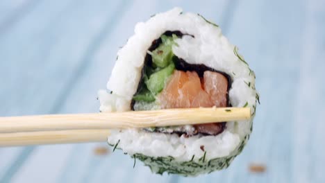 rollo de sushi de salmón con palillos