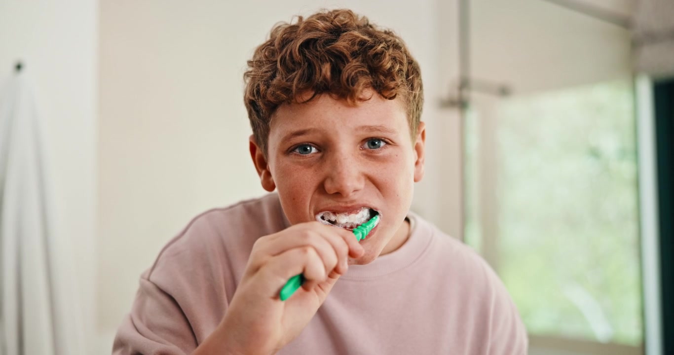 Young Boy Brushing Teeth in Bathroom