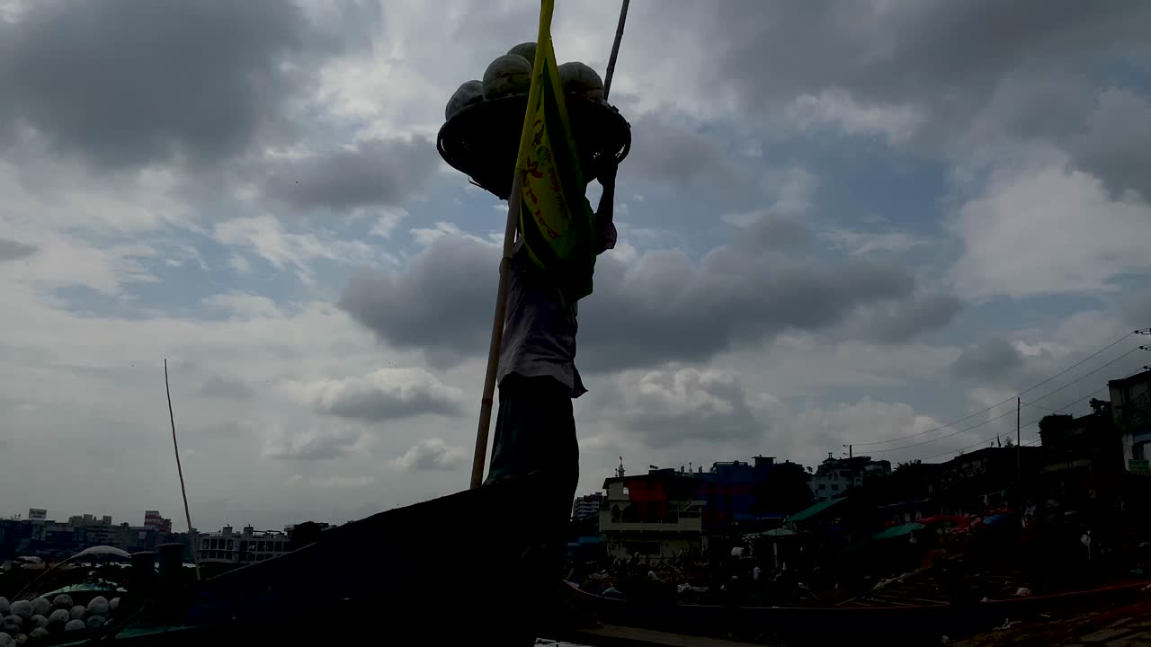 trabajador diario que lleva una cesta de verduras en la cabeza en el puerto fluvial de bangladesh