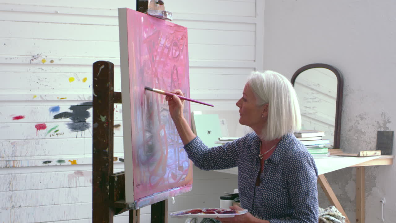 r3d로 촬영된 스튜디오에서 그림을 그리는 여성 예술가