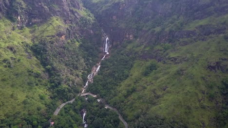 Inclinación-Aérea:-La-Carretera-De-La-Selva-Montañosa-Cruza-La-Cascada-En-Sri-Lanka