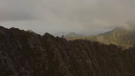 man standing on mountain drone reveal