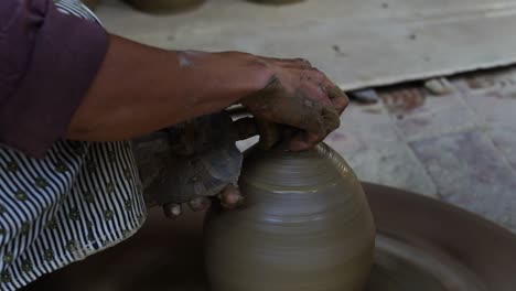 woman potters rotate a wheel with her foot and making a clay pot, vietnam