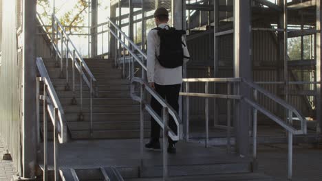 man walking up metal stairs