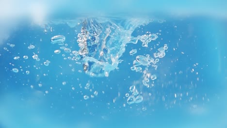 bubbles under water on a blue background. bubbles from pouring water. 4k slow motion video.