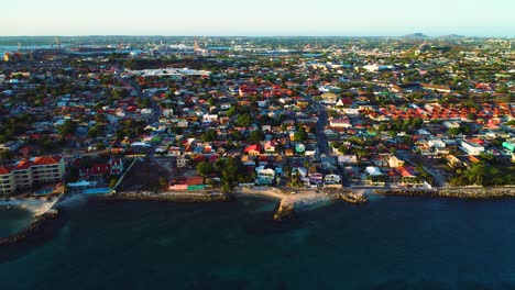 Sweeping-aerial-view-above-Pietermaai,-Punda,-and-Willemstad-Curacao-at-sunset