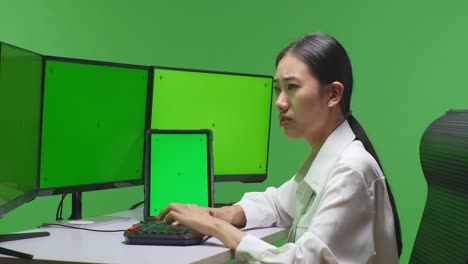 woman working on multiple monitors and a tablet