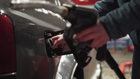 Refueling-car-fuel-tank-on-gas-station,-hand-holding-nozzle,-side-closeup