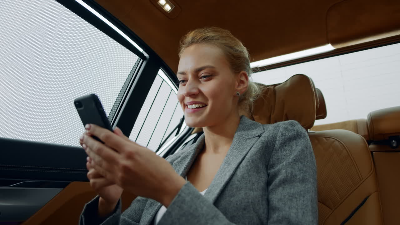 en primer plano una mujer de negocios emocionada celebrando la victoria en un vehículo.