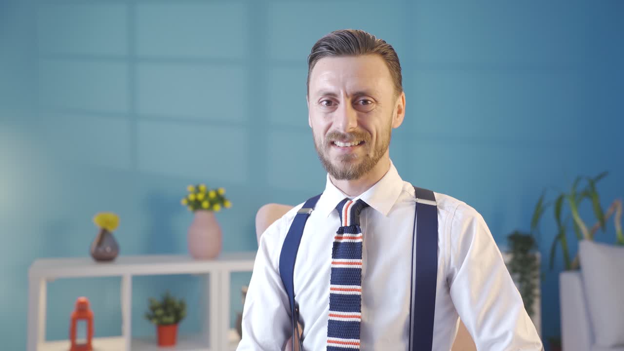 카리스마 있고 우아한 젊은이가 카메라를 향해 미소 짓고 있습니다. 이 잘생긴 사업가는 독특한 옷차림과 라이프 스타일을 가지고 있습니다.