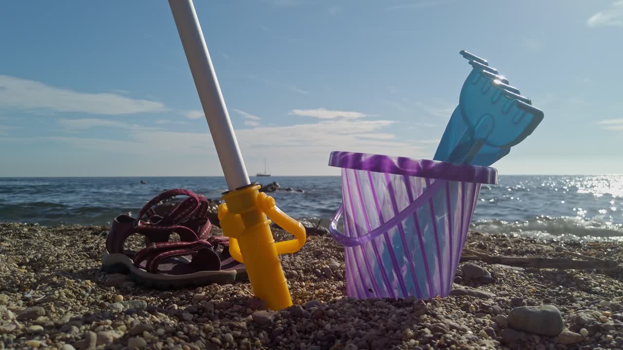 Toys On The Beach With Bucket, Spade, And Shovel On Sand