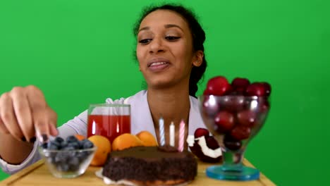 una chica negra feliz acaba de salir de la cama con pastel de cumpleaños.