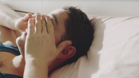 young transgender man waking up in bed