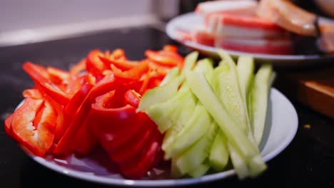 Alejándose-Del-Plato-De-Rodajas-De-Tomate-Y-Pepino,-Listo-Para-La-Preparación-De-Sushi