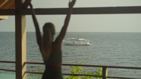 Woman-practicing-sun-salutation-yoga-pose-with-focus-on-boat-floating-in-water