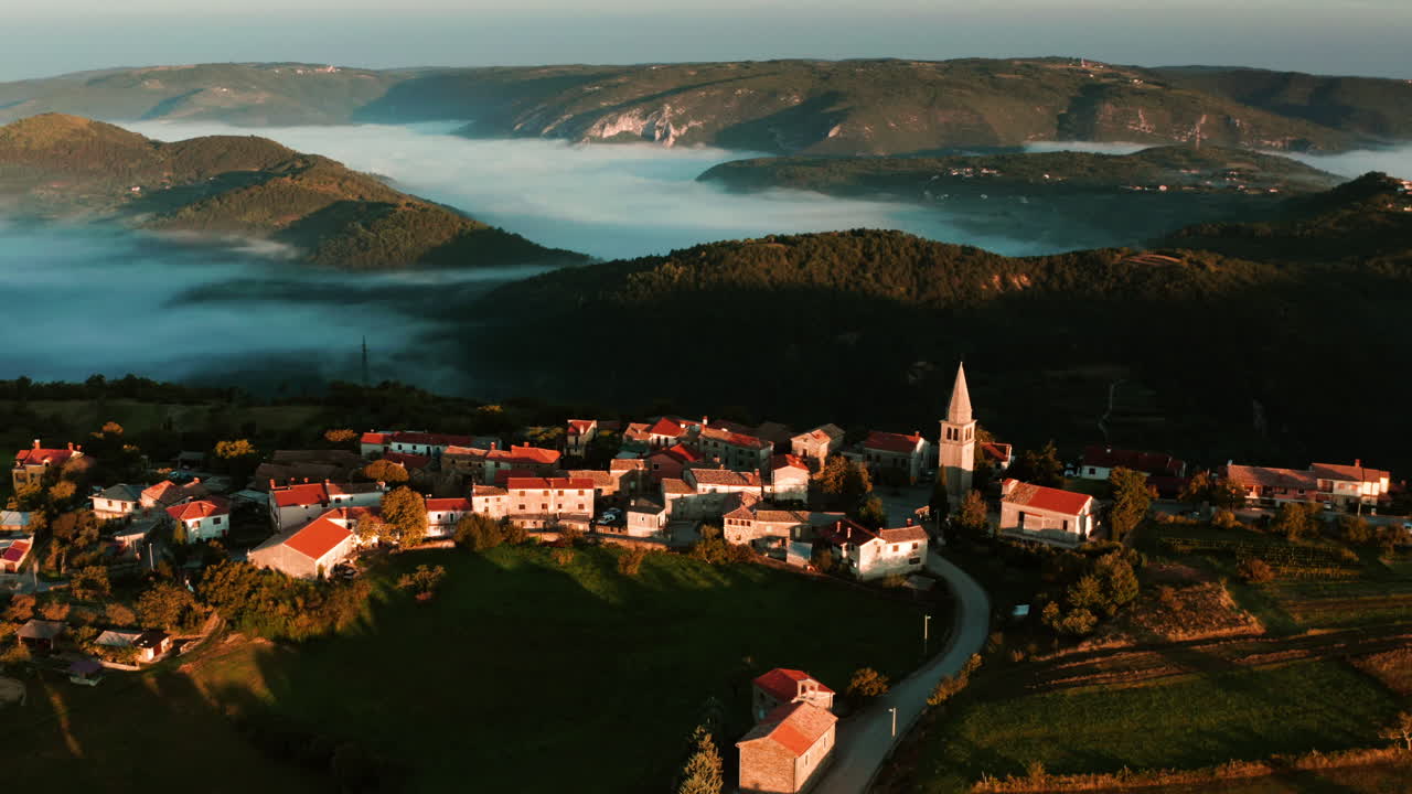 Vista mozzafiato del borgo medievale di Vrh con paesaggio collinare sullo sfondo durante l'alba in Istria, Croazia