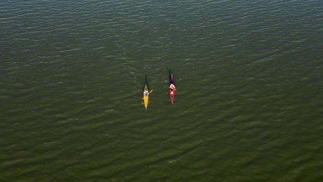 Kayaks-paddling-across-a-lake-at-sunset