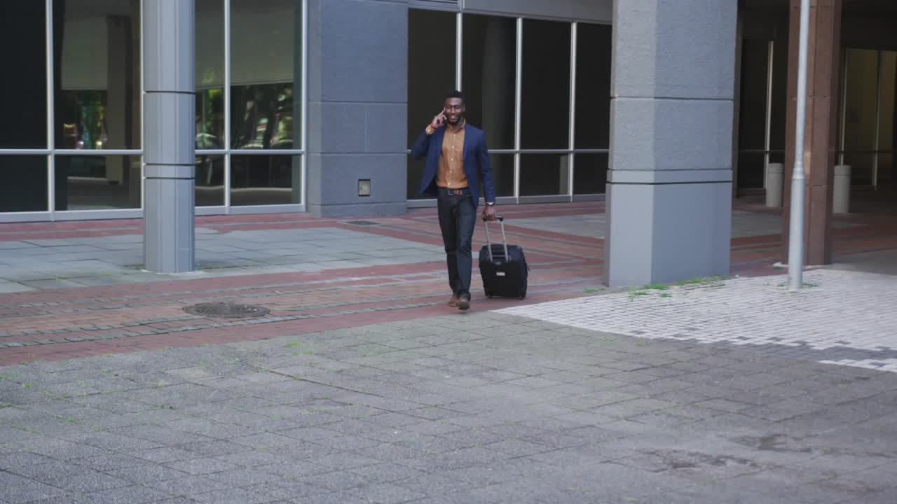 Executive walking forward talking on phone towing suitcase, call causing holographic map over him