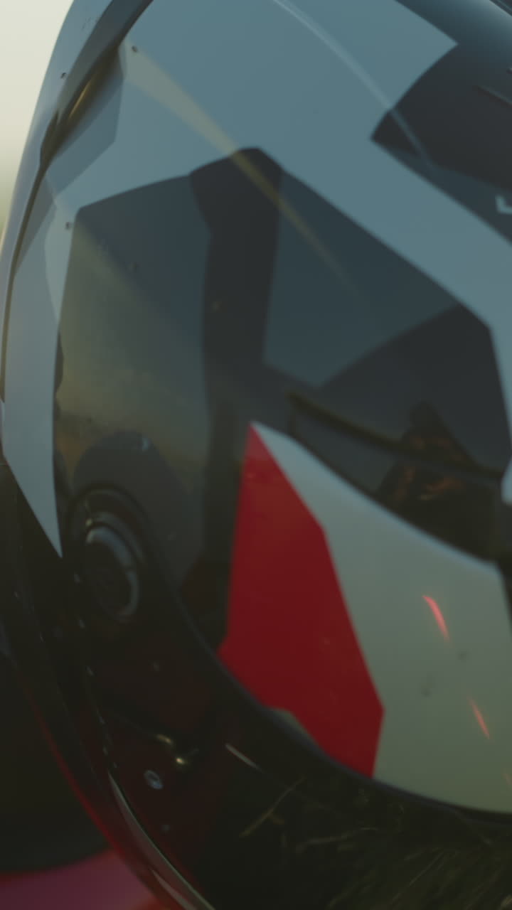 primer plano de un manillar de motocicleta con un casco apoyado en él y la llave de encendido insertada, con la luz natural reflejando suavemente