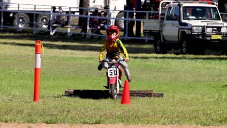 child competes in motocross event, showcasing skill.