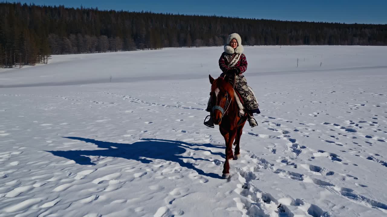 A person rides a horse across a snowy landscape, captured from a low-angle shot