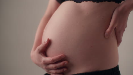la mujer se masajea suavemente el vientre durante el embarazo