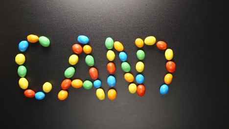 vista superior: letras de caramelo escritas por caramelos de colores (movimiento de parada)
